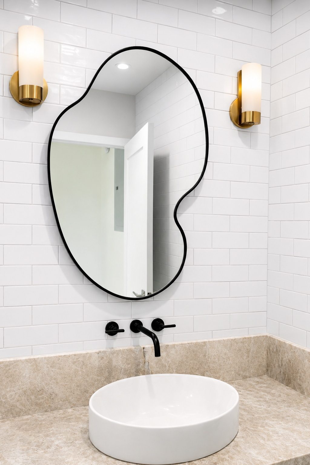Black-framed pebble-shape mirror over a subway-tile bathroom