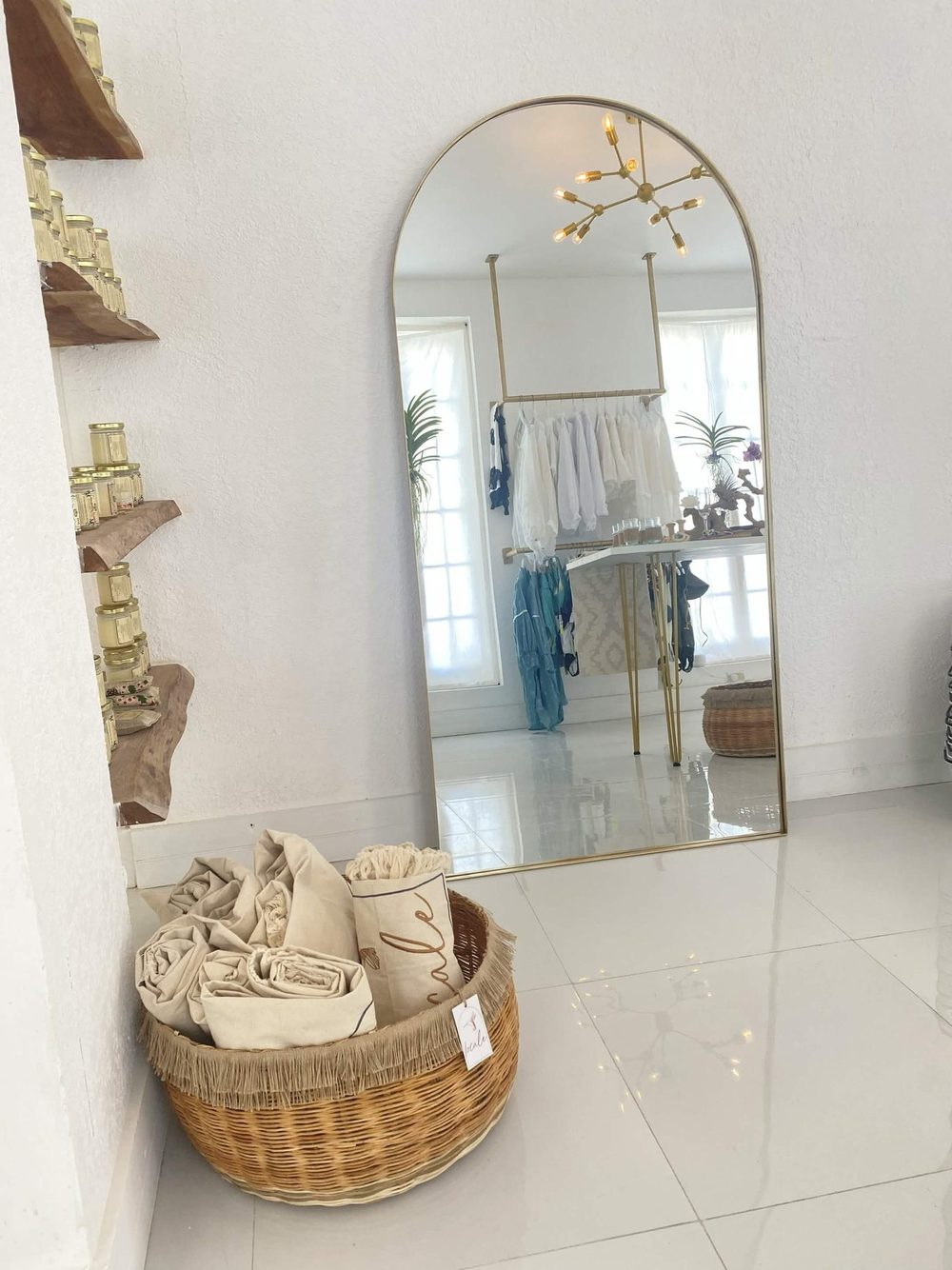 Arched brass mirror set against a white wall