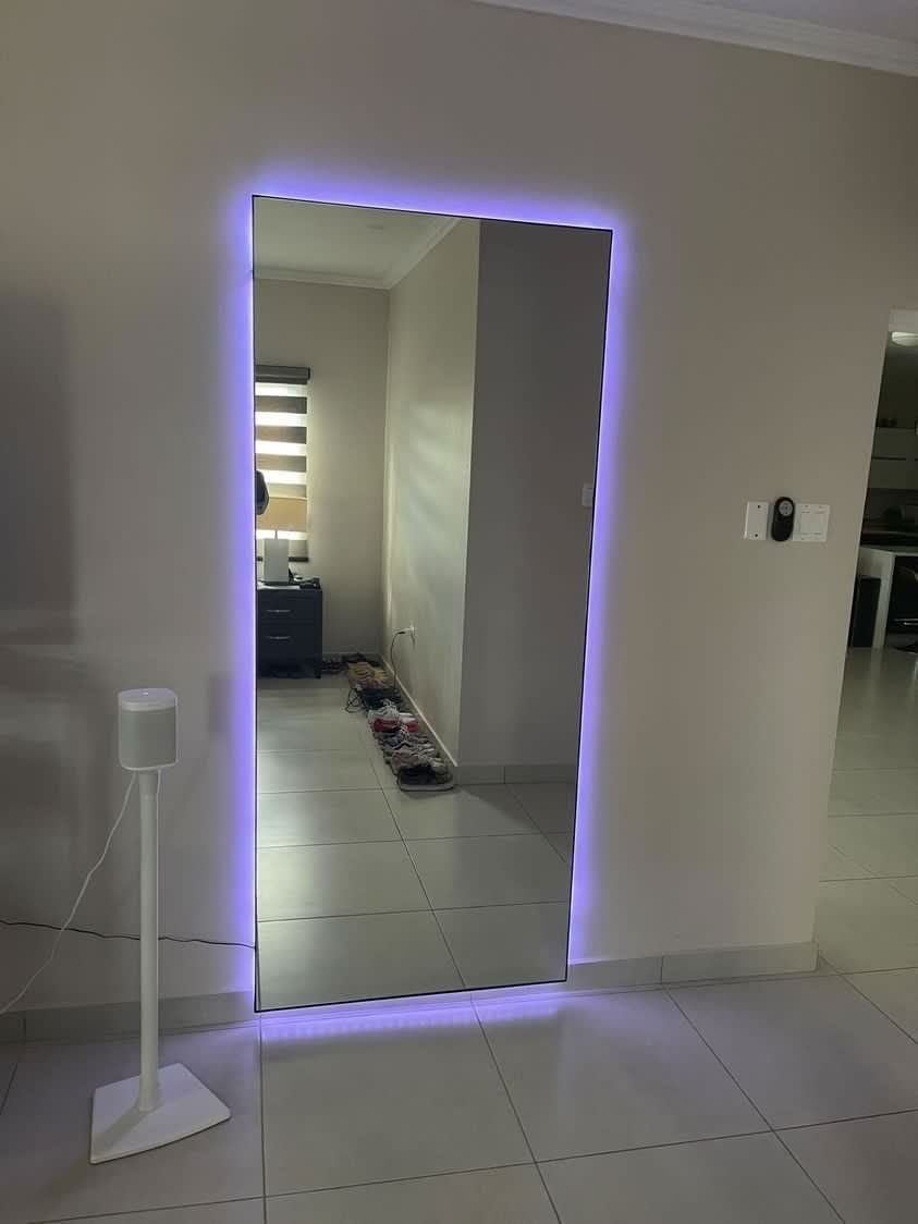 LED-backlit full-length mirror in a living space