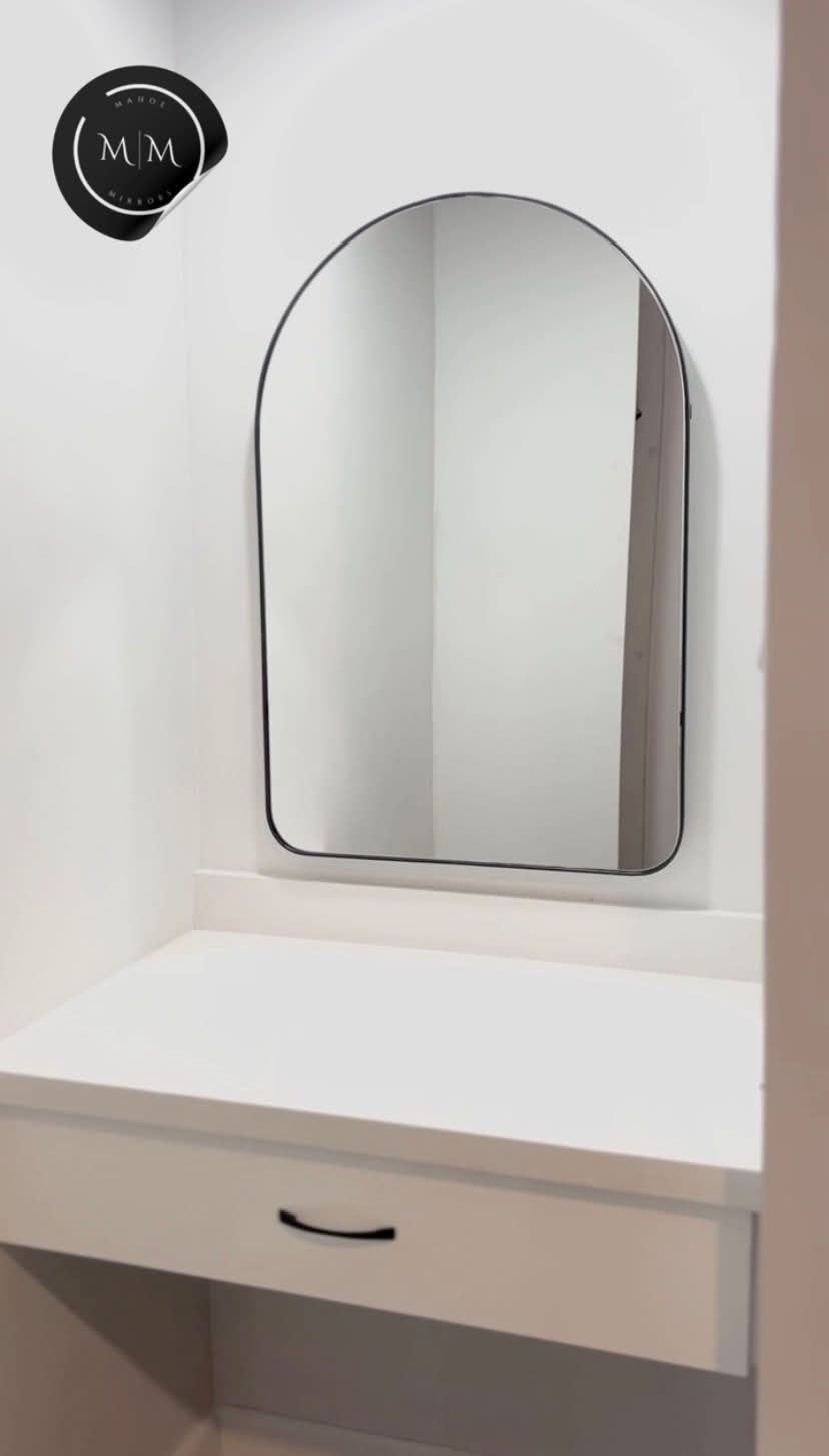 Small arched mirror over a built-in vanity